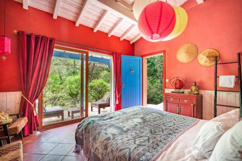 a bedroom with red walls and a bed and a window at Moulin de Lassalle in Linxe