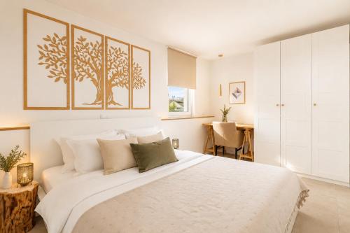 a white bedroom with a large bed and a desk at Premium Residence Virotel in Vir