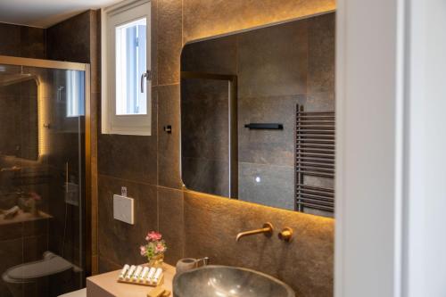 a bathroom with a sink and a mirror at Elysium Exclusive Villas in Áyioi Saránda