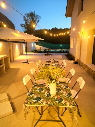 a long table with plates and flowers on a patio at Casa La Huertona de Castroserna in Castroserna de Arriba