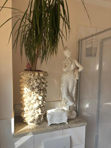 a statue of a woman sitting on a shelf with a plant at Little Cottage auf 2 Etagen in Raben Steinfeld