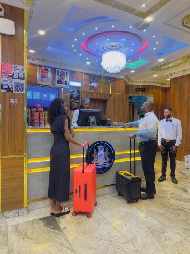 a woman standing in front of a ticket counter with her luggage at Don Marble Hotel And Suites in Auchi