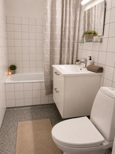 a white bathroom with a toilet and a sink at Stor 2 værelses lejlighed in Randers