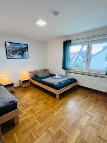 a bedroom with a bed and two windows at Ferienwohnung Adelsried 2 in Adelsried