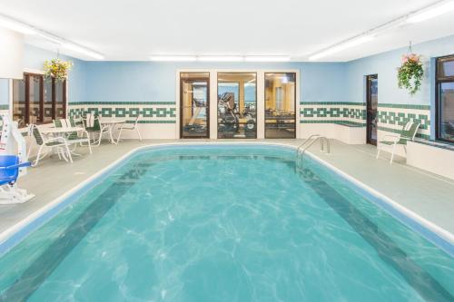 a large pool in a room with chairs and tables at Ramada Limited Decatur in Forsyth