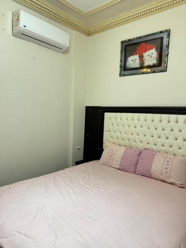 a bedroom with a white bed with a white headboard at Ras elbar Palace in Ras El Bar