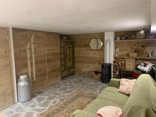 a living room with wooden walls and a couch at Baita Lodge Valfreda in Falcade