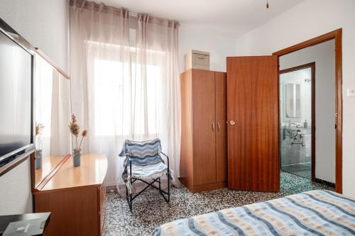 a bedroom with a bed and a desk and a chair at Piso DE-MI-LA in Aspe