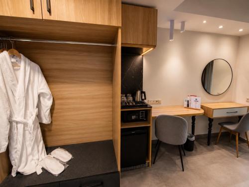 a room with a desk and a closet with a mirror at Hotel Pella in Giannitsa