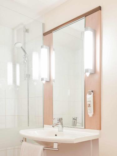 a bathroom with a sink and a mirror at ibis Sint Niklaas Centrum in Sint-Niklaas