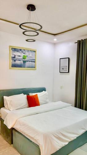 a bedroom with a large bed with orange and white pillows at Premium Height in Ikate
