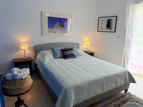 a bedroom with a bed and two lamps and a window at Art & Motion Union - Guest Room 4 in Andros