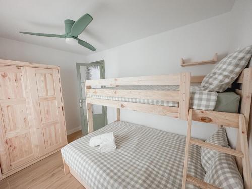 a bedroom with two bunk beds and a ceiling fan at Apartaments Angelina in La Pobla de Segur