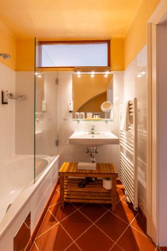 a bathroom with a sink and a tub and a mirror at Schlosshotel Mailberg in Mailberg