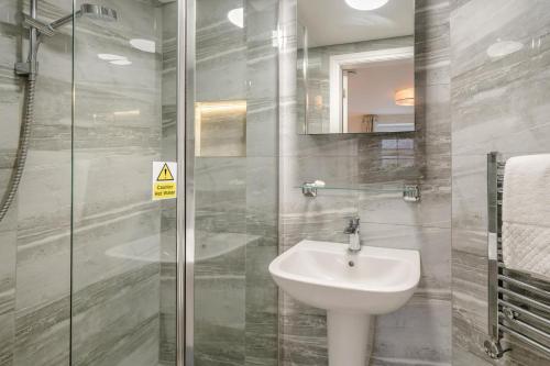 a bathroom with a sink and a glass shower at 1 Bed in Lytham St. Annes oc-86044 in Saint Annes on the Sea