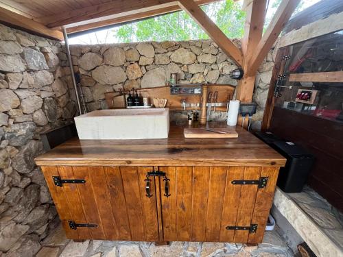 a kitchen with a sink and a stone wall at 4Rest Villa in Novalja