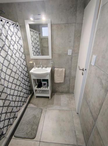 a bathroom with a sink and a shower with a mirror at Las Heras in Bahía Blanca
