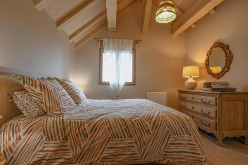 a bedroom with a bed with a dresser and a window at La ferm'hier in Balnot-sur-Laignes