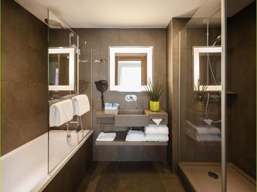 a bathroom with a sink and a shower at Novotel SPA Rennes Centre Gare in Rennes