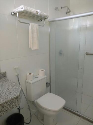 a white bathroom with a toilet and a shower at Hotel Parque das Aguas in Aracaju