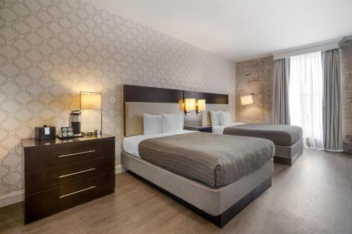 ein Hotelzimmer mit zwei Betten und einer Kommode in der Unterkunft Best Western Plus St. Christopher Hotel in New Orleans