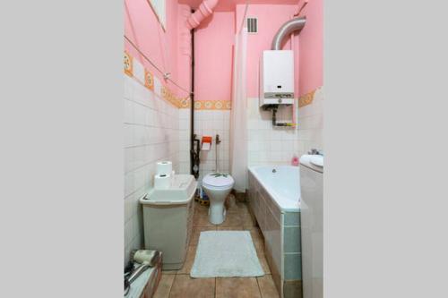 a bathroom with a toilet and a tub and a sink at Feel The Old Socialist Style Apartment in Krakow