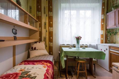 a small room with a table and a table and a kitchen at Feel The Old Socialist Style Apartment in Krakow