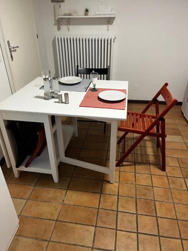 a white table with plates on it in a kitchen at Monolocale Cerreto Laghi in Cerreto Laghi