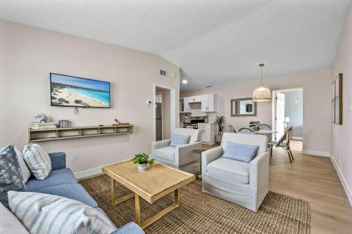 a living room with a couch and two chairs and a table at Breakwater Bungalow in Cocoa Beach