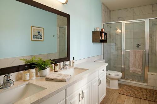 a bathroom with a sink and a toilet and a mirror at The Island Hotel Near Beach Port Aransas in Port Aransas