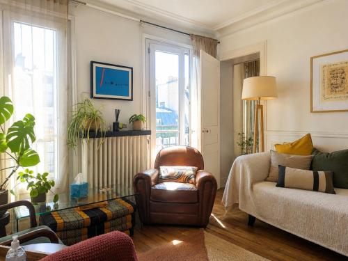 a living room with a couch and a chair at Charmant appartement au cœur de Paris in Paris