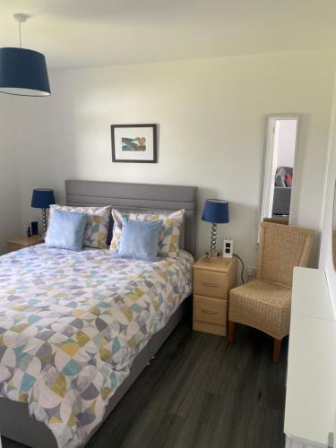 a bedroom with a bed and a chair at Almondbank Cottage 8 miles from Portree 2 bedrooms sleeps 3 adults in Skeabost