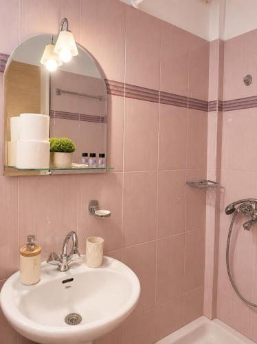 a bathroom with a sink and a shower at PNOÉ rooms in Ilia