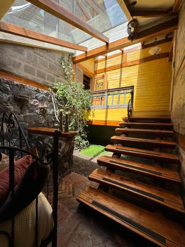a porch with stairs and a stone wall at Hacienda Rumiloma in Quito