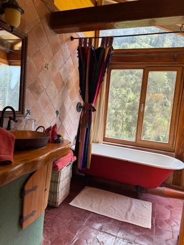 a bathroom with a bath tub and a window at Hacienda Rumiloma in Quito