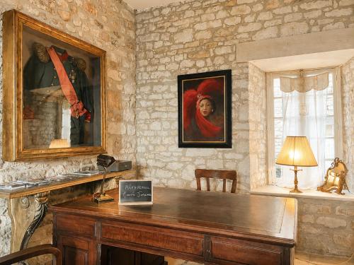 a wooden desk in a room with a painting on the wall at Manoir Jorama - ancien musée de Joséphine Baker in Castelnaud La Chapelle
