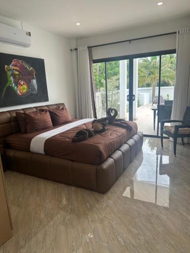 a bedroom with a large bed in a room with sliding glass doors at AVANA Villa in Nathon Bay
