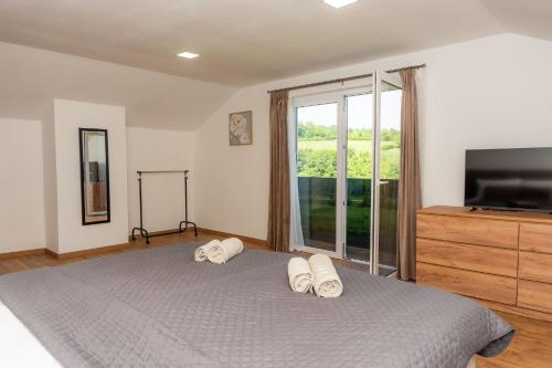 a bedroom with a bed with a television and a dresser at Korana River Retreat with Sauna & Jacuzzi and View by Destination GREEN Croatia in Barilović