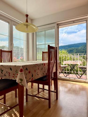 a dining room with a table and chairs and a balcony at Apartments Gorje Hideaway in Spodnje Gorje