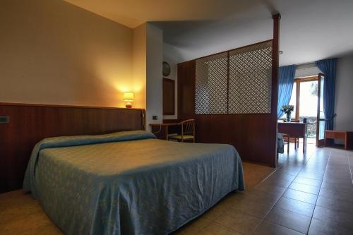 a bedroom with a bed and a table and chairs at Hotel Ristorante Il Gabbiano in Passignano sul Trasimeno