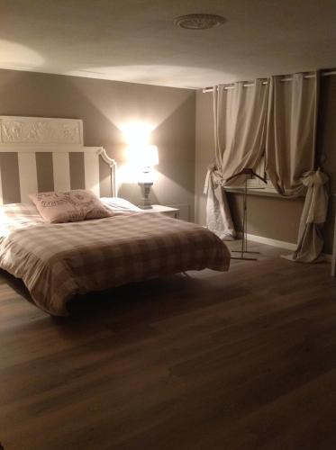 um quarto com uma cama com um candeeiro e cortinas em SUITE 5 em Reggio Emilia