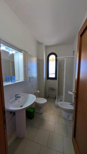 a bathroom with two sinks and a shower and two toilets at Appartamenti Lungomare Via Roma in Castiglione della Pescaia