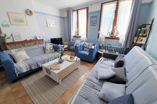 a living room with two couches and a table at Le Maluthina Maison Familiale au Hourdel entre Mer & Nature in Cayeux-sur-Mer