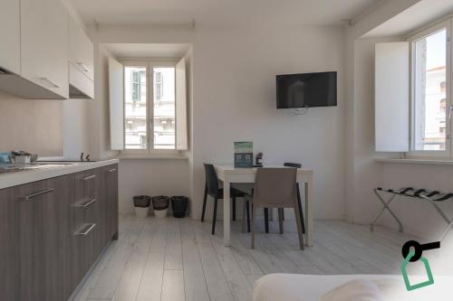 a kitchen with a table and a tv on the wall at Hotiday Trieste Corso Italia in Trieste