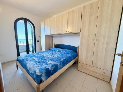 a bedroom with a bed and a wooden cabinet at Appartamenti Lungomare Via Roma in Castiglione della Pescaia