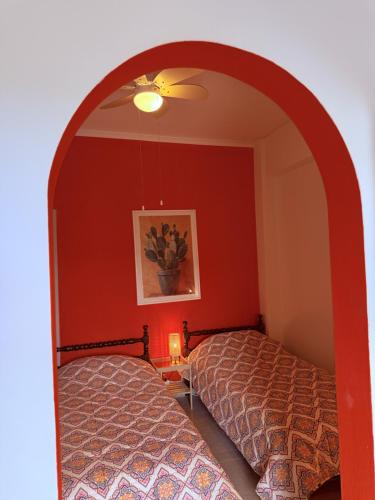 a bedroom with two beds and a red wall at Art & Motion Union - Guest Room 5 in Andros
