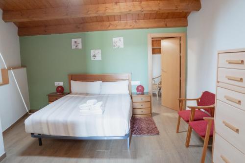 a bedroom with a bed and a chair at Apartaments Ca L'Albert in La Pobla de Segur