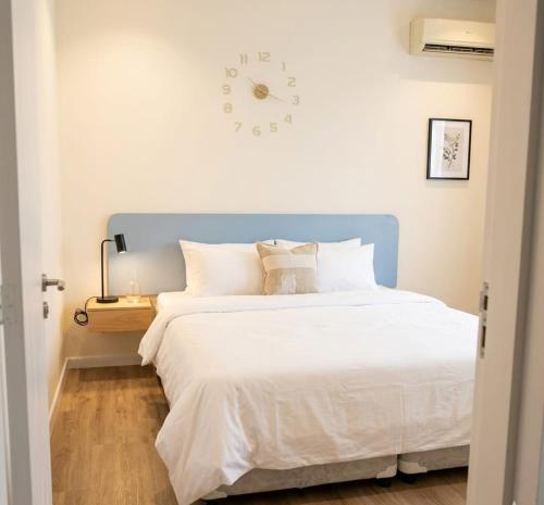 a bedroom with a large bed with a clock on the wall at M Residence in Accra