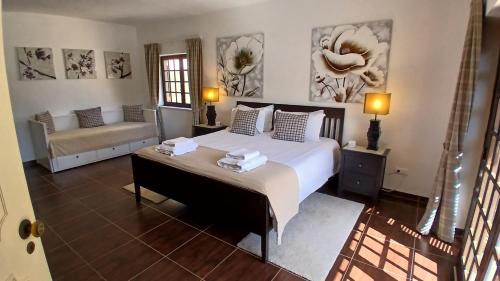 a bedroom with a large bed and a couch at Casa Grande Holidays in São Martinho do Porto