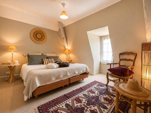 a bedroom with a bed and a table and a chair at Manoir Jorama - ancien musée de Joséphine Baker in Castelnaud La Chapelle